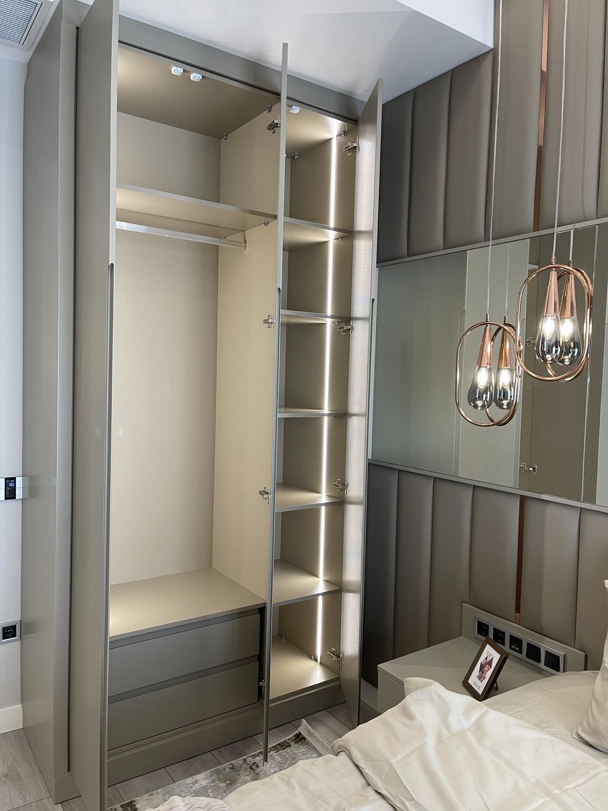 Custom wardrobe interior with LED-lit shelving and hanging rails